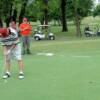 Jim Tucker putts while Fred Treolo, "Beetle" Bailey and Trey Shurmon look on.