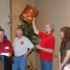 Randy Dunham holds "Alligator" Jack's 40,000th Graduate Plaque high.